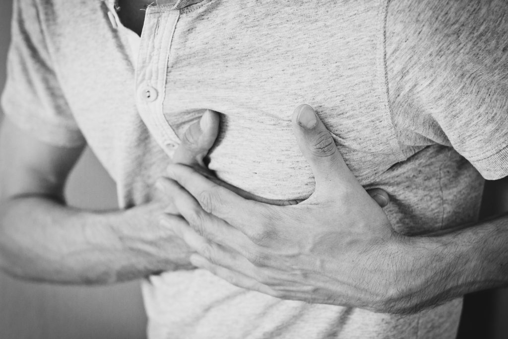 man holding chest during heart attack